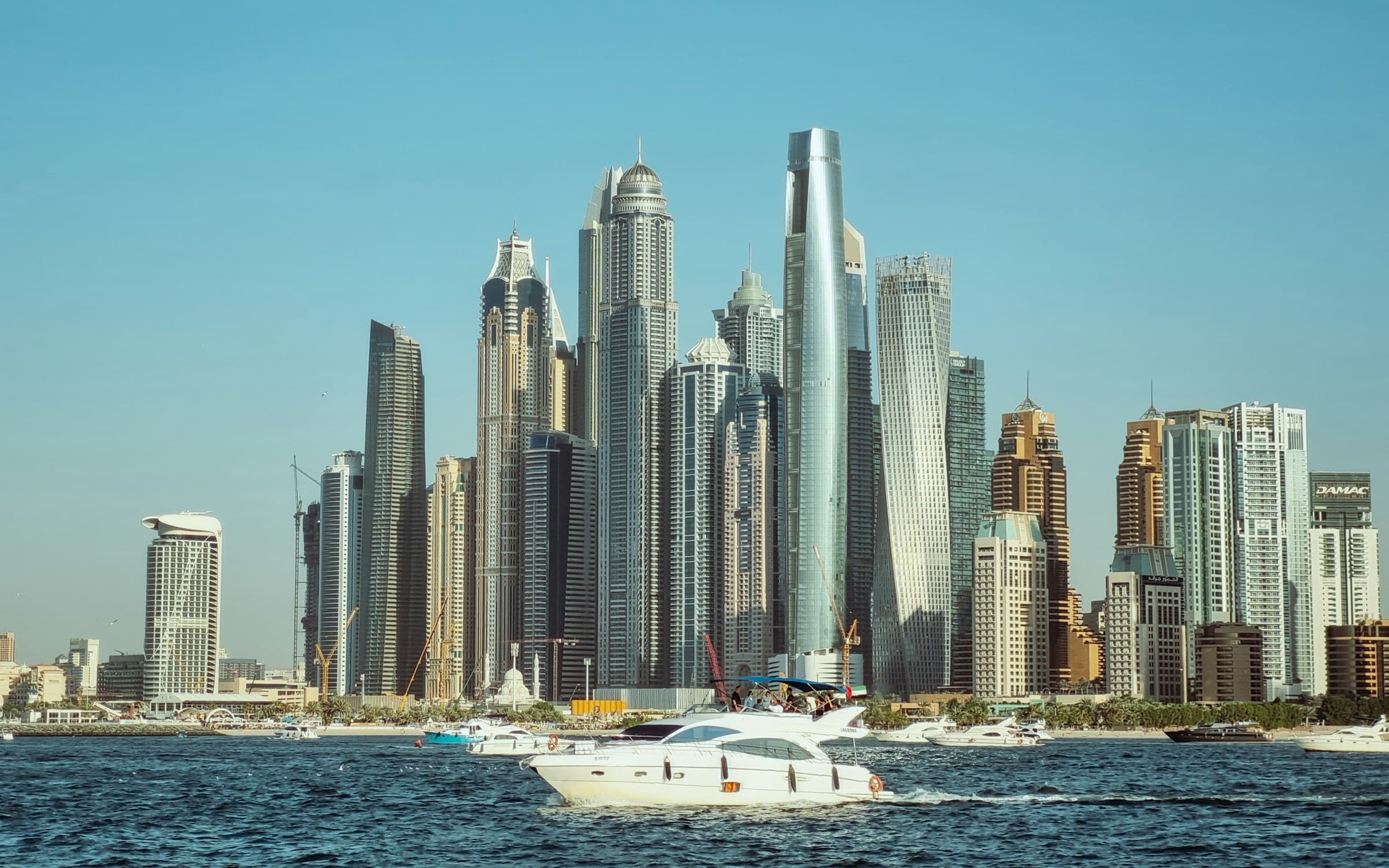 Motor yacht underway in Dubai Marina, with the marina skyline behind it